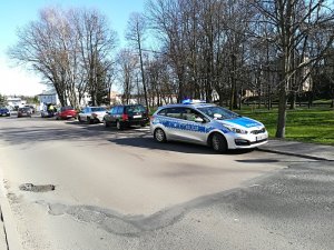 trzy pojazdy stojące na chodniku uczestnicy zdarzenia drogowego volkswagen, Peugeot i Fiat a także zaparkowany policyjny radiowóz