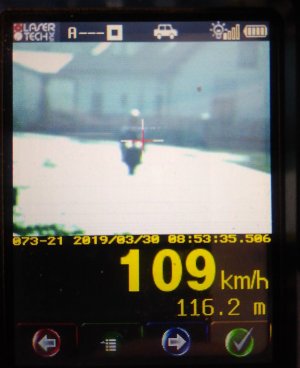 zrzut z ekranu urządzenia kontrolującego prędkość kierujących. na pierwszym planie kierujący na motocyklu. Poniżej cyfra 109 wskazująca prędkość z jaką jedzie motocyklista