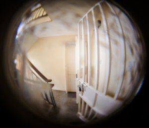 Widok klatki schodowej z wizjera od drzwi wejściowych